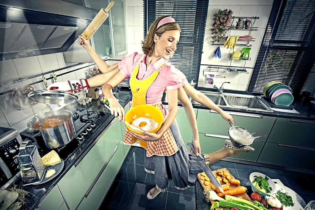 Обнажённая хозяюшка на кухне готовит ужин